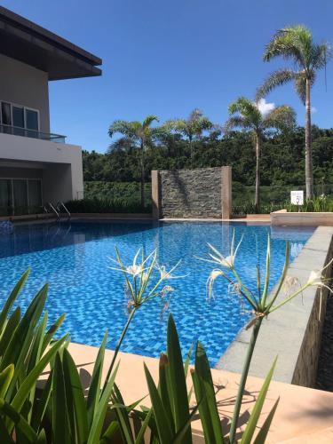 a swimming pool in front of a house with palm trees at Belmont Hotel Boracay near Newcoast Beach in Boracay