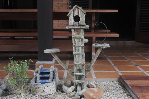 a bird house with a bird feeder and some rocks at Hostel Trópico de Capricórnio - Tenório in Ubatuba