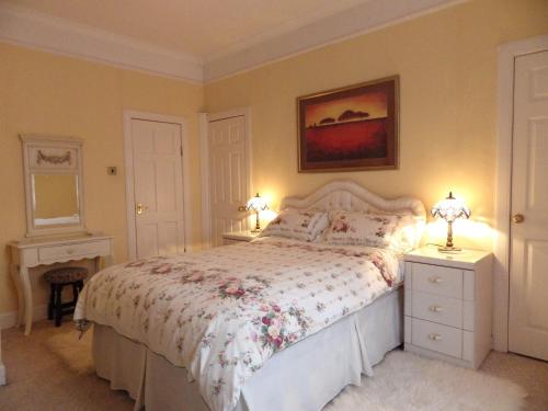 a bedroom with a bed and two lamps and a dresser at The Central Guesthouse in Kelso