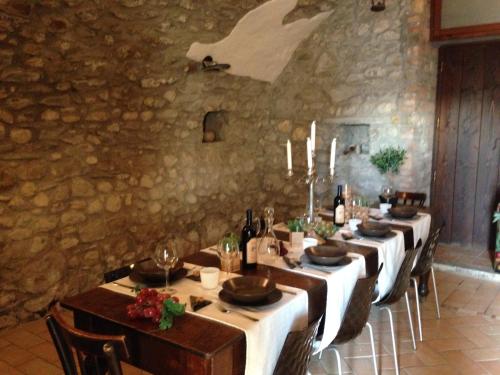 Villongo SantʼAlessandroにあるB&B Videttiの石壁のダイニングルーム(長いテーブル付)