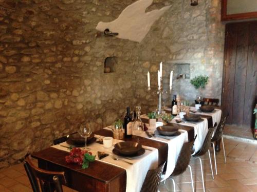 a dining room with long tables and a stone wall at B&B Videtti in Villongo SantʼAlessandro
