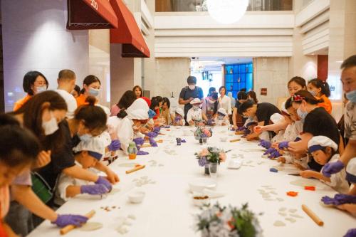 a group of people sitting around a long table with flowers at Shangri-La Suzhou in Suzhou