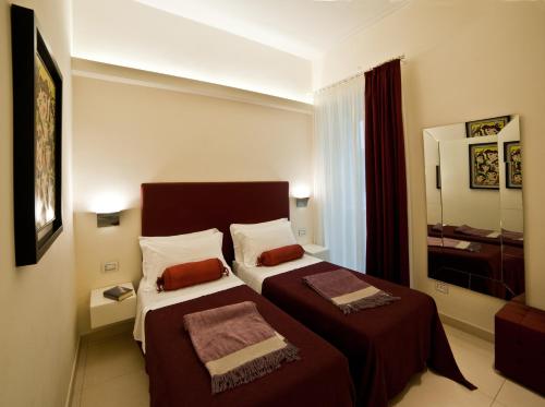 a hotel room with two beds and a mirror at Town House Cavour in Reggio Calabria