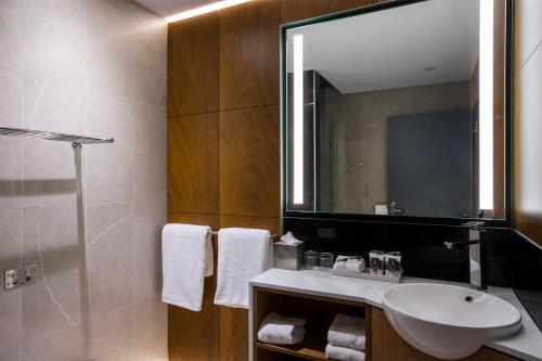 a bathroom with a sink and a mirror at Mercure Sydney Liverpool in Liverpool