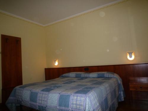 sypialnia z łóżkiem i 2 lampkami na ścianie w obiekcie La Cerquetta w mieście Trevi