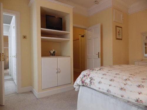 a bedroom with a bed and a tv on a wall at The Central Guesthouse in Kelso
