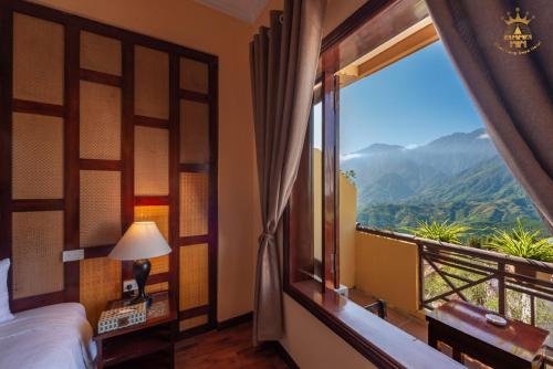 a bedroom with a bed and a window with a view at Chau Long Sapa 2 Hotel in Sa Pa