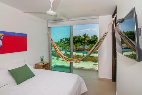 ein Schlafzimmer mit einem Bett und einer Hängematte in der Unterkunft Magico Apartamento Frente al Mar 3 Habitaciones MSC22 in Coveñas