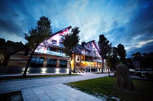 a building is lit up at night at Hotel Piwniczna SPA&Conference in Piwniczna