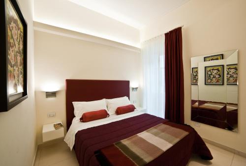 a bedroom with a large bed with two red pillows at Town House Cavour in Reggio Calabria