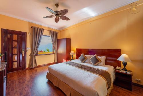 a bedroom with a large bed and a ceiling fan at Chau Long Sapa 2 Hotel in Sa Pa