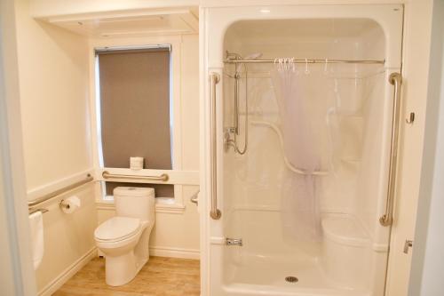 bagno bianco con servizi igienici e doccia di Rum Runner Inn a Lunenburg