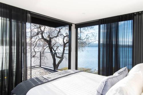 a bedroom with a bed and a view of the water at Deviot Boat House in Deviot