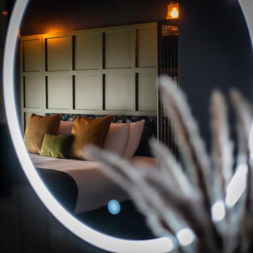 a reflection of a bed with pillows in a mirror at The Baltic Hotel in Liverpool