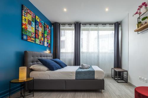 a bedroom with a bed and a blue wall at ESCAPE time - Paris in Gentilly