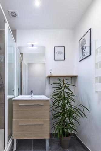 a bathroom with a sink and a potted plant at ESCAPE time - Paris in Gentilly
