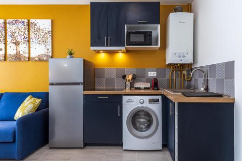 a kitchen with a refrigerator and a washing machine at ESCAPE time - Paris in Gentilly