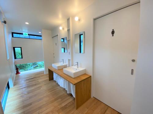 a bathroom with two sinks and a large mirror at B&B KAMAKURA in Kamakura