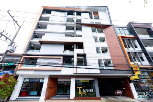 a tallartment building with a store in front of it at Thongmanee Hotel in Hat Yai