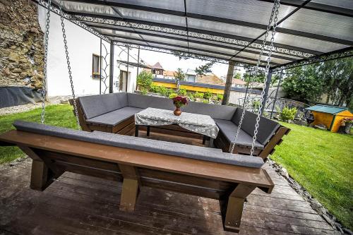 a porch swing with a couch and a table at Villa Zachar in Ľubica