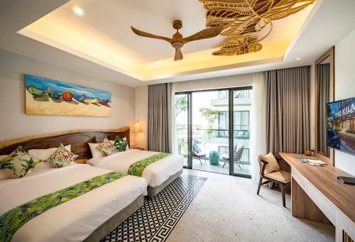 pokój hotelowy z dwoma łóżkami i telewizorem w obiekcie The Kila Boutique Hotel w mieście Quy Nhơn