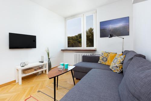 a living room with a couch and a tv at Apartments Warsaw Browarna by Renters in Warsaw