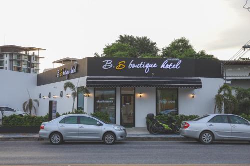 two cars parked in front of a building at B.S Boutique Hotel in Bangsaen