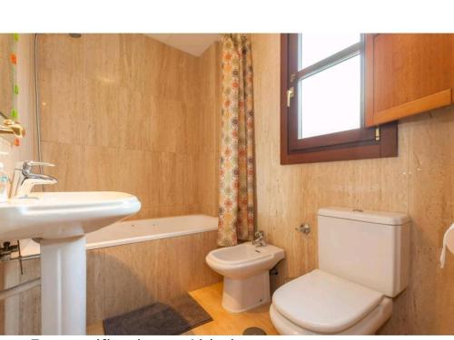 een badkamer met een wit toilet en een wastafel bij Atico padre Aldama in Sanlúcar de Barrameda