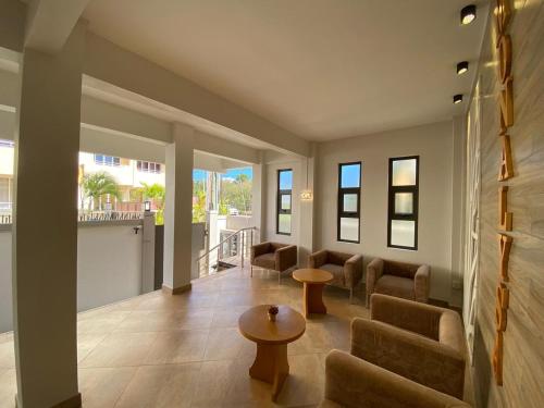 a living room with couches and a table and windows at The Monalysa Suites & Residence in Grand Baie