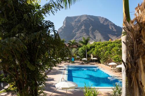 a swimming pool with a mountain in the background at Residencial El Llano in Valle Gran Rey