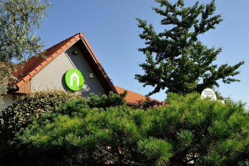 a house with a green sign on the side of it at Campanile Toulouse Sesquieres in Toulouse