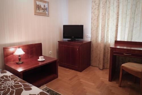 a hotel room with a bed and a tv and a table at Pokoje Gościnne Pałac w Balicach Instytut Zootechniki PIB in Balice