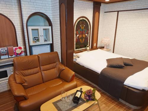 Munakata Pal (Love Hotel) في Munakata: غرفة نوم بسرير واريكة وطاولة