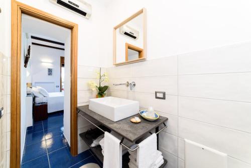 a bathroom with a white sink and a mirror at La Valle Delle Najadi in Vietri sul Mare