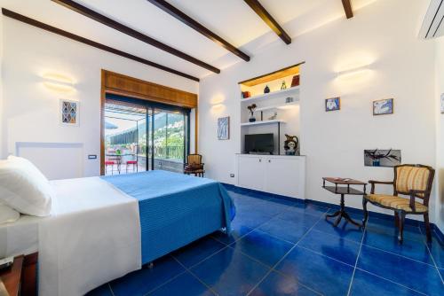 a bedroom with a bed and a desk and a television at La Valle Delle Najadi in Vietri sul Mare