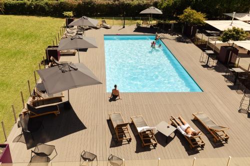 an overhead view of a swimming pool with chairs and umbrellas at Novotel Nancy in Nancy