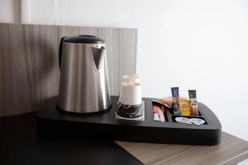 a coffee maker sitting on a black tray at Saphir Grenelle in Paris