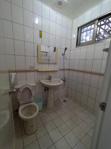 a bathroom with a toilet and a sink at Lanting Yazhu B&B in Renai
