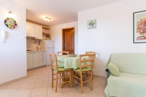 a kitchen and dining room with a table and chairs at Apartmani Manzoni in Punat