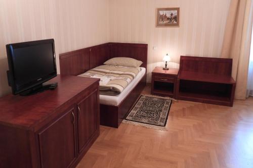 a room with a bed with a tv and a table at Pokoje Gościnne Pałac w Balicach Instytut Zootechniki PIB in Balice