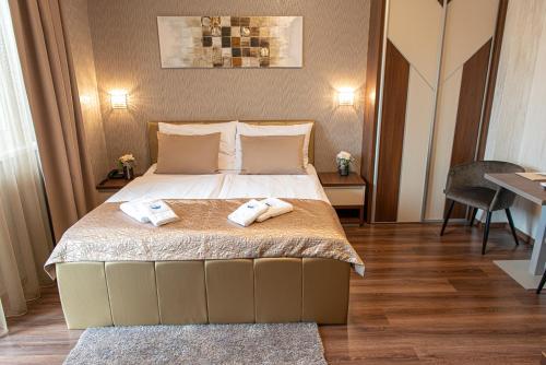 a bedroom with a bed with two towels on it at Villa Dunaj in Dunajská Streda