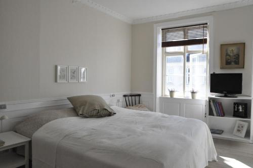 a white bedroom with a bed and a window at ApartmentInCopenhagen Apartment 331 in Copenhagen