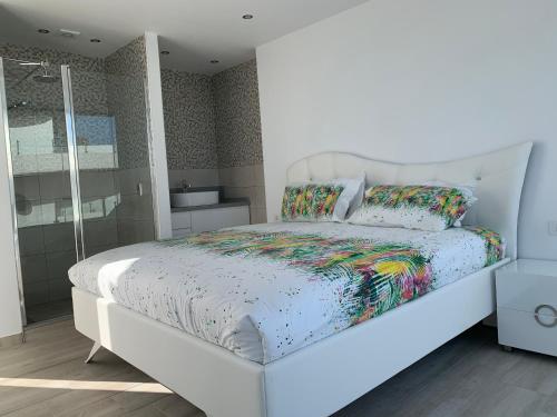 a bedroom with a white bed with a white headboard at Penthouse Las Olas in Palm-Mar