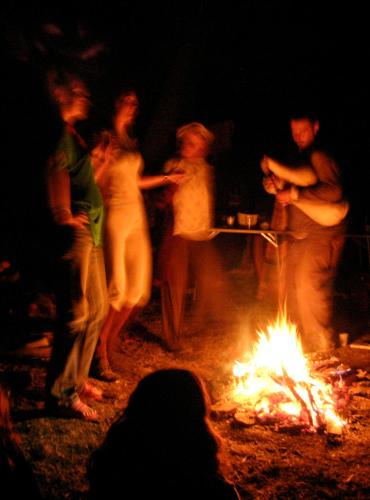 a group of people standing around a fire at Къща край реката - Триград in Trigrad