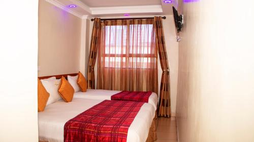 a bedroom with a bed with a red and white blanket at Sheratton Regency Hotel Nairobi in Nairobi