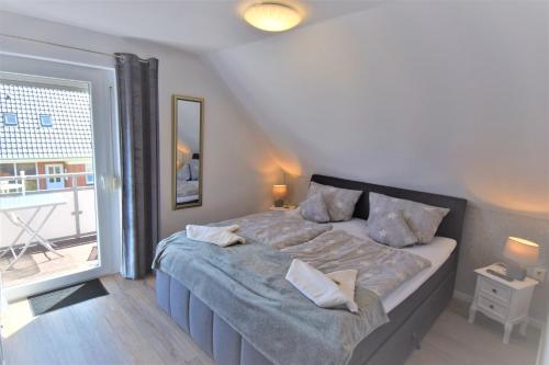 1 dormitorio con cama grande y ventana grande en Schatzinsel, en Büsum