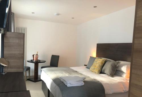 a bedroom with a bed and a table with a chair at The Bell Guesthouse in Peterlee