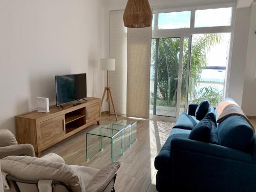 een woonkamer met een blauwe bank en een tv bij Casa Carla in Arrecife