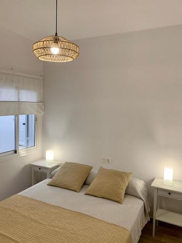 a white bedroom with a bed with two pillows at Casa Carla in Arrecife