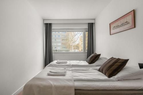 Cette chambre comprend un grand lit et une fenêtre. dans l'établissement Kotimaailma Kuopio, à Kuopio